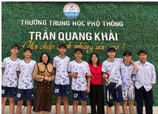 Đội bóng chuyền hơi lớp 11A1 chụp ảnh lưu niệm cùng hai cô giáo trước cổng Trường THPT Trần Quang Khải