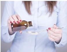 người cầm lọ thuốc Paracetamol và thìa
