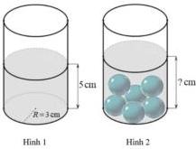 Hình 1 và Hình 2 mô tả chiếc cốc thủy tinh hình trụ chứa nước cao 5 cm trước và sau khi thả 6 viên bi sắt